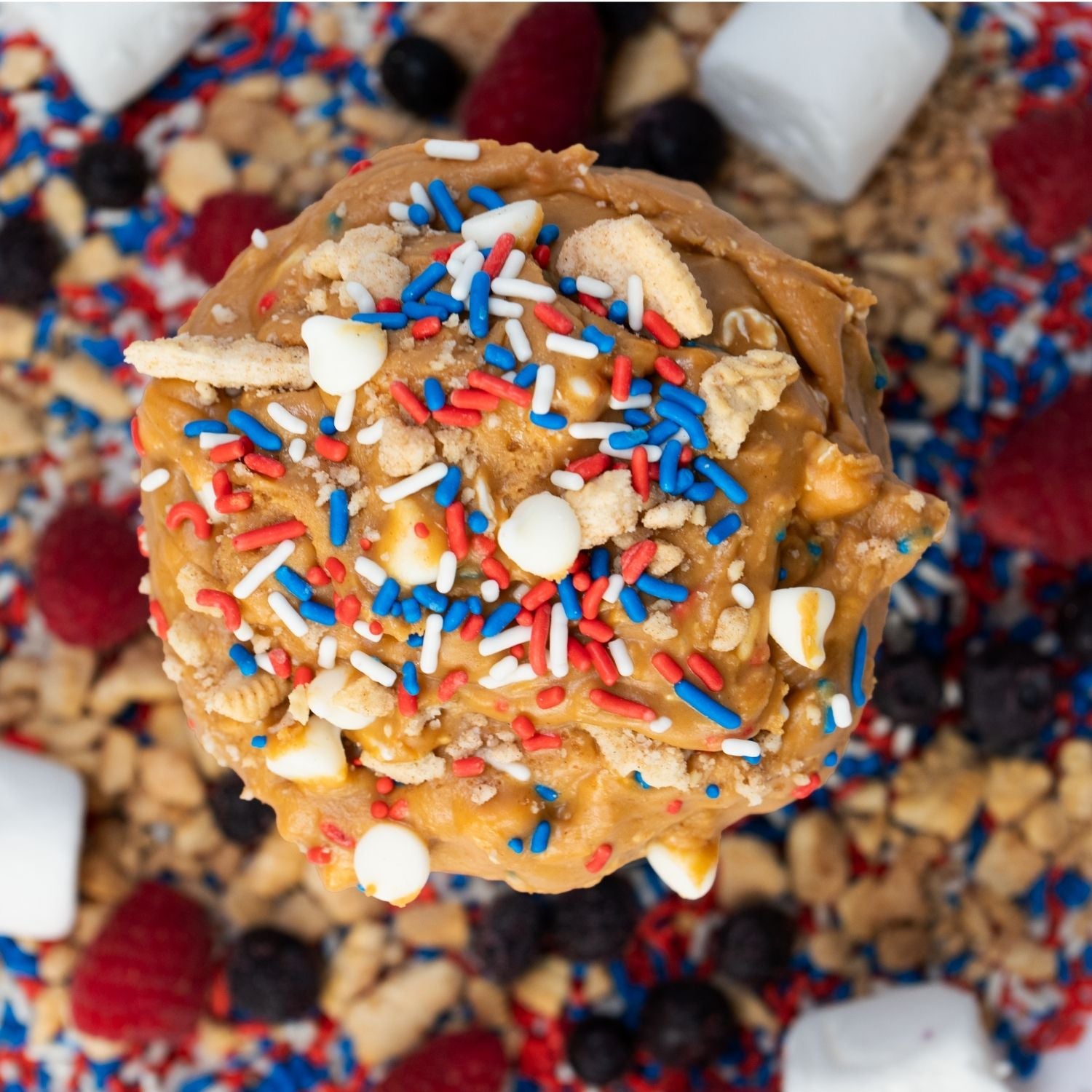Close-up of a cookie with colorful sprinkles on a background of cookies and candies.